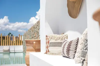 two pictures of a couch with pillows on a balcony at Zàia Suites & Living, Suite N2, pool view in Gennadi