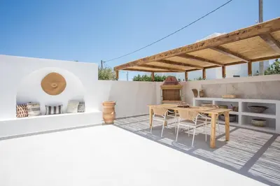 a patio with a wooden table and chairs at Zàia Suites & Living, Suite N2, pool view in Gennadi