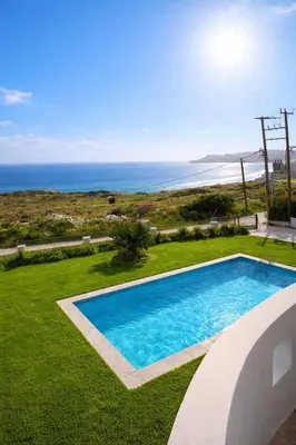 a swimming pool with the ocean in the background at Kalithea Sunrise in Rhodes Town