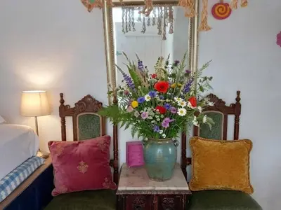 a vase of flowers on a table in a bedroom at Heritage House Malonas in Malona Village