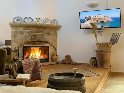 a living room with a fireplace and a tv at Heritage House Malonas in Malona Village