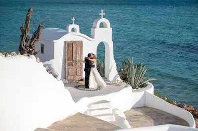 a bride and groom kissing in front of a church at Axiotheaton Villa Lydia in Pefki Rhodes