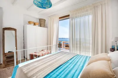 a bedroom with a large bed and a large window at Axiotheaton Villa Lydia in Pefki Rhodes