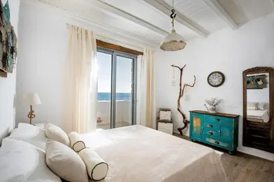 a white bedroom with a large bed and a window at Axiotheaton Villa Lydia in Pefki Rhodes