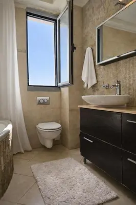 a bathroom with a sink and a toilet and a window at Alkion in Asgourou