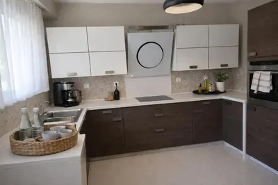 a kitchen with white cabinets and a sink and a counter at Alkion in Asgourou