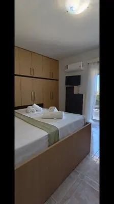 a bedroom with a large white bed with cabinets at Louloudakis Apartment in Koskinou