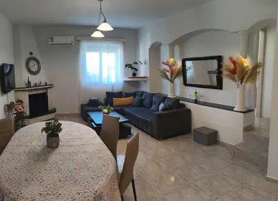 a living room with a blue couch and a table at Louloudakis Apartment in Koskinou