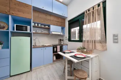 a kitchen with blue cabinets and a table in it at Loft 146 in Rhodes Town