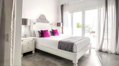 a white bedroom with a large bed with pink pillows at Villa Rafael in Lindos, Rhodos for 8gst in Líndos