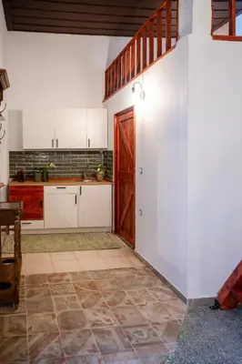 a kitchen with white cabinets and a wooden door at St Nicholas traditional house in Rhodes Town