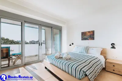 a bedroom with a bed and a balcony at Rhodes Port Haven Suite in Rhodes Town