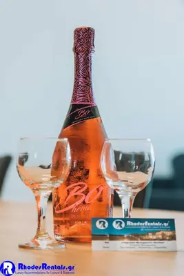 a bottle and two glasses on a table at Rhodes Port Haven Suite in Rhodes Town