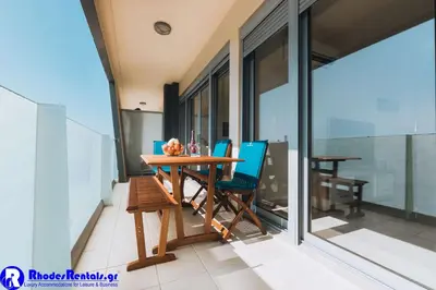 a dining room with a table and chairs on a balcony at Rhodes Port Haven Suite in Rhodes Town