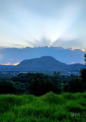 a view of a mountain range with a rainbow in the sky at Sea-Nature-Wellness in Kolimbia