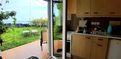 a kitchen with a sliding glass door to a garden at Sea-Nature-Wellness in Kolimbia