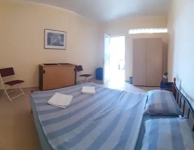 a bedroom with a blue bed with two towels on it at Sea-Nature-Wellness in Kolimbia