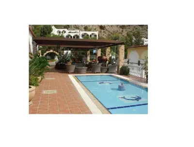 a swimming pool with a pergola next to a house at Coralli Apartments in Pefki Rhodes