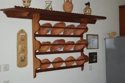 a shelf filled with lots of bowls and vases at Mano's House in Monólithos