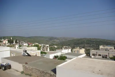 a person sitting on top of a roof with a skateboard at Mano's House in Monólithos