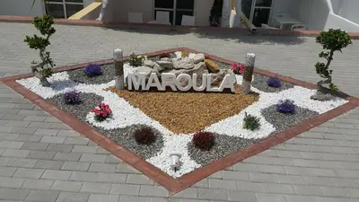 a flower bed with a marula sign in the middle at Casa Blue Sarantis in Faliraki