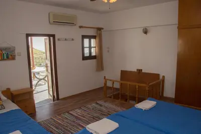 a bedroom with a blue bed and a balcony at Jacks Studios in Líndos