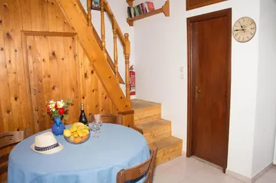 a blue table with a bowl of fruit and a clock at Jacks Studios in Líndos