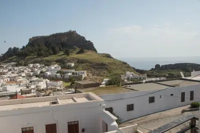 a view of a town with a hill in the background at Jacks Studios in Líndos