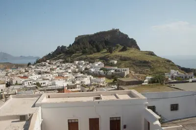 a view of a town with a hill in the background at Jacks Studios in Líndos