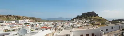 a view of a town with white buildings on a hill at Jacks Studios in Líndos