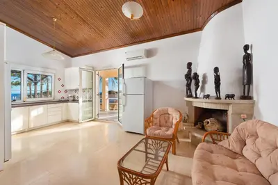 a living room with a couch and a fireplace at Villa Maria Beachfront Residence in Kiotari
