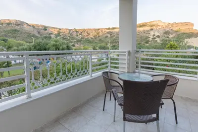 a balcony with two chairs and a table at Faliraki Dream Studios & Apartments in Faliraki