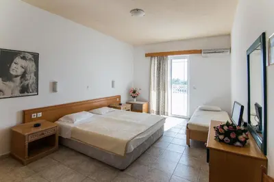 a hotel room with two beds and a television at Faliraki Dream Studios & Apartments in Faliraki