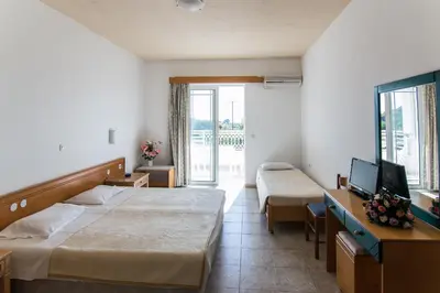 a hotel room with two beds and a television at Faliraki Dream Studios & Apartments in Faliraki