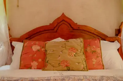 a bed with a wooden headboard and two pillows at Elafusa Luxury Apartment in Rhodes Town