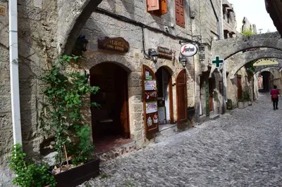 an alley in a stone building with a person walking down the street at Elafusa Luxury Apartment in Rhodes Town
