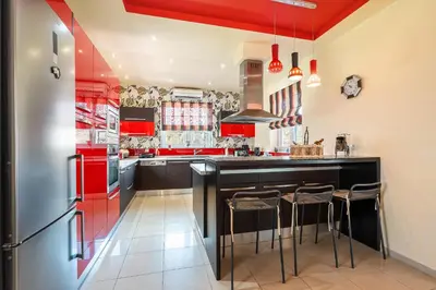 a kitchen with red cabinets and a black counter at Paramithia Villa in Afantou