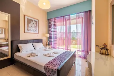 a bedroom with a bed and a large window at Paramithia Villa in Afantou