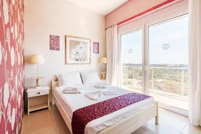 a bedroom with a bed and a large window at Paramithia Villa in Afantou