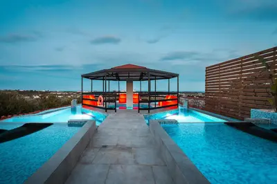 a swimming pool with a gazebo on top of a building at Paramithia Villa in Afantou