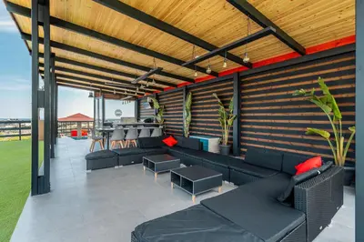 a patio with black couches and a wooden wall at Paramithia Villa in Afantou