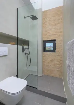 a bathroom with a shower and a toilet at Albatross Beach Front Villas in Gennadi
