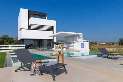 a villa with a swimming pool and a house at Albatross Beach Front Villas in Gennadi