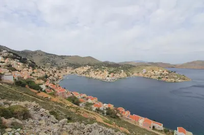 a town on a hill next to a body of water at Athanasia's House in Symi
