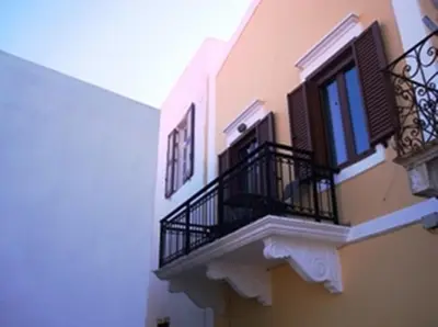 a building with black balconies and a window at Athanasia's House in Symi