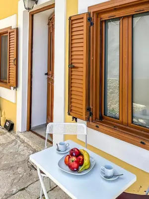 a plate of fruit on a table outside a window at Athanasia's House in Symi