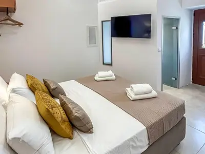 a bedroom with a bed with pillows and a tv at Athanasia's House in Symi