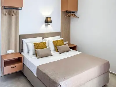 a bedroom with a large bed with yellow pillows at Athanasia's House in Symi
