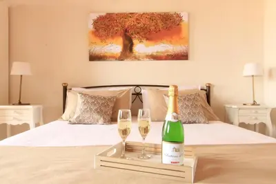 a bottle of champagne and two glasses on a bed at Athanasia's House in Symi