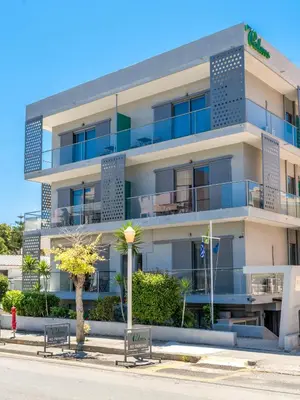 a white building with benches in front of it at 7Palms in Rhodes Town